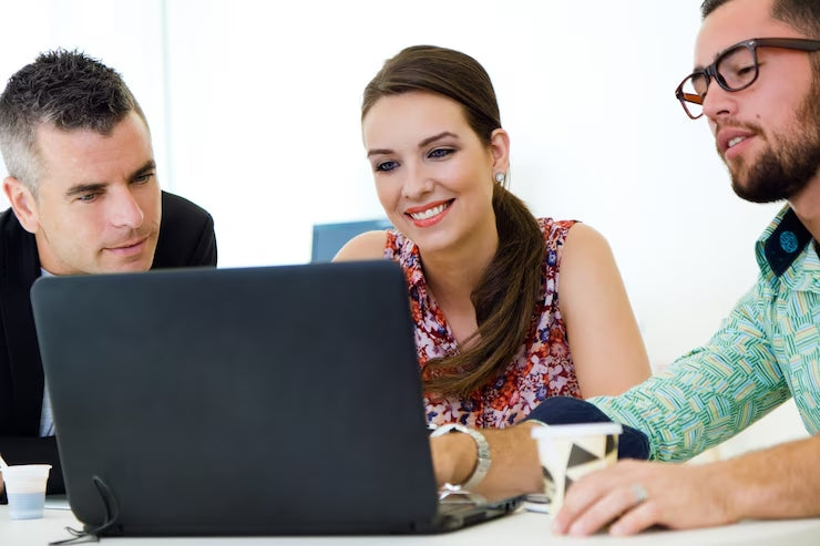 Gruppo di professionisti che collaborano su un laptop in un ambiente di lavoro moderno