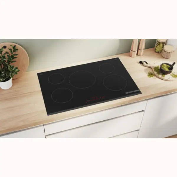 Piano cottura BOSCH in vetroceramica nero con cinque zone di cottura integrato in cucina moderna