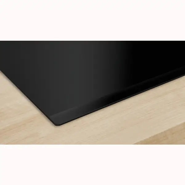 Piano cottura BOSCH nero con superficie liscia e design moderno installato su piano in legno chiaro