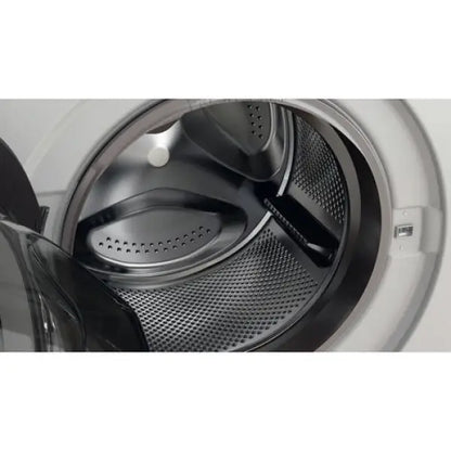 Interno del cestello di una lavatrice Whirlpool con sportello aperto e design in acciaio inox