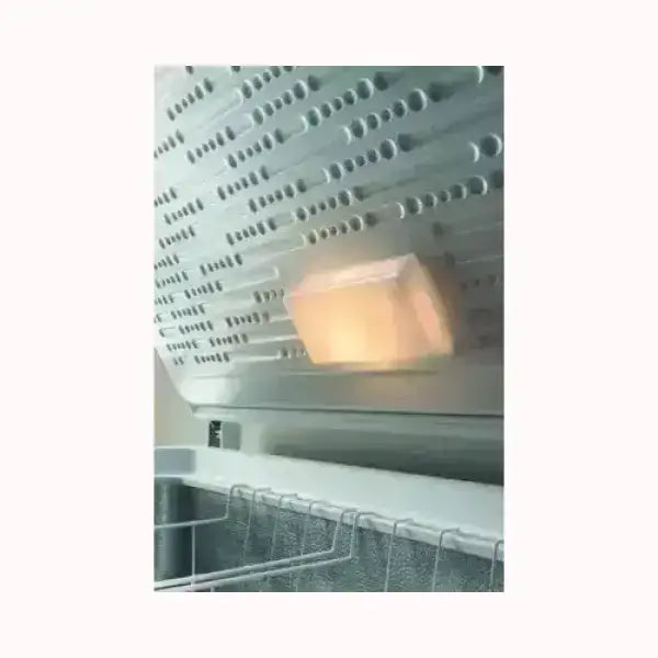 Dettaglio interno del congelatore INDESIT con sistema di raffreddamento e griglia metallica
