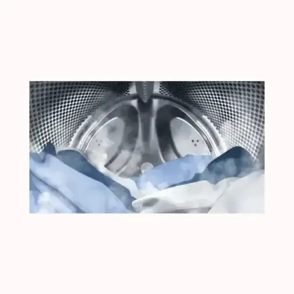 Interno lavatrice INDESIT con capi in lavaggio nel cestello in acciaio inox