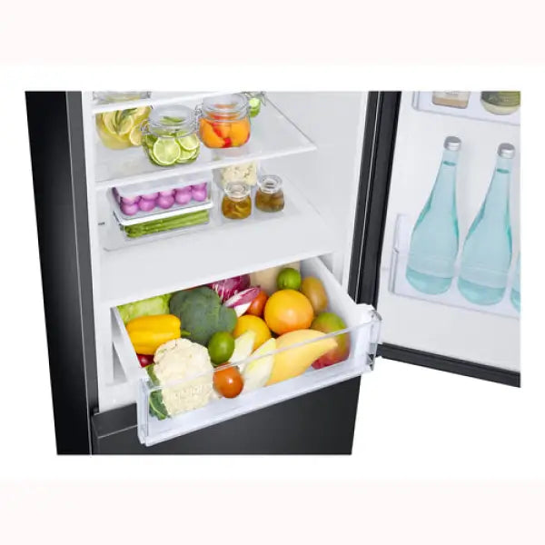 Interno di frigorifero combinato Samsung con ripiani e cassetto verdure pieni di frutta e verdura fresca