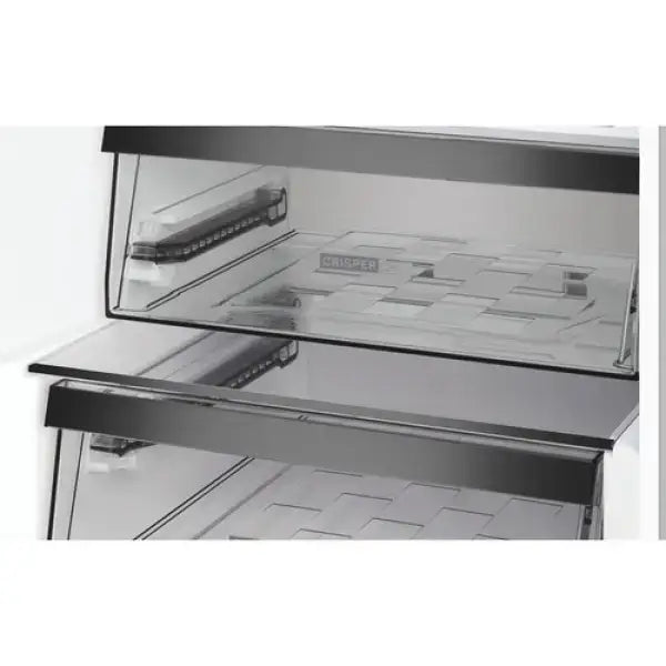 Dettaglio interno del frigo combinato Whirlpool con ripiani in vetro trasparente e cassetto crisp