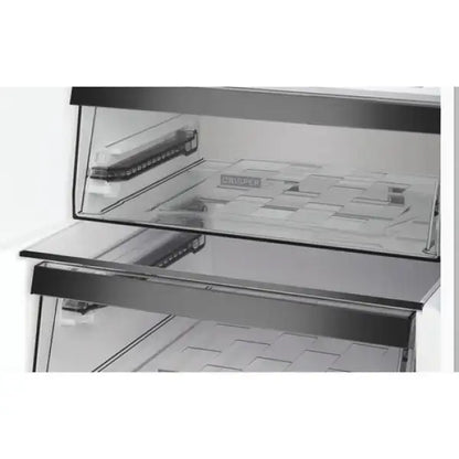 Dettaglio interno del frigo combinato Whirlpool con ripiani in vetro trasparente e cassetto crisp