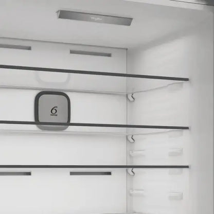 Interno bianco del frigorifero Whirlpool con ripiani in vetro trasparente e sistema Fresh Control